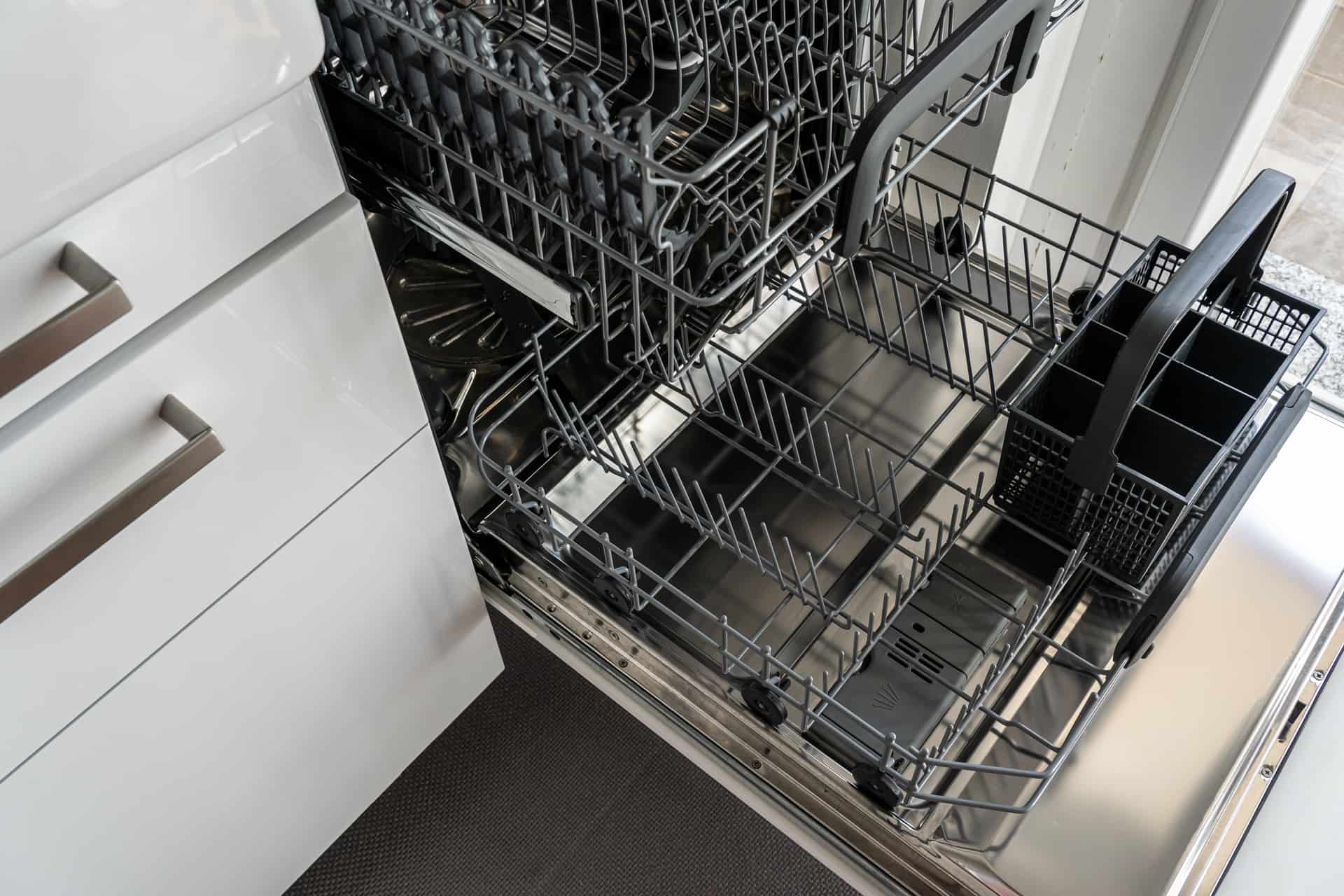 An open dishwasher rack in a bright kitchen